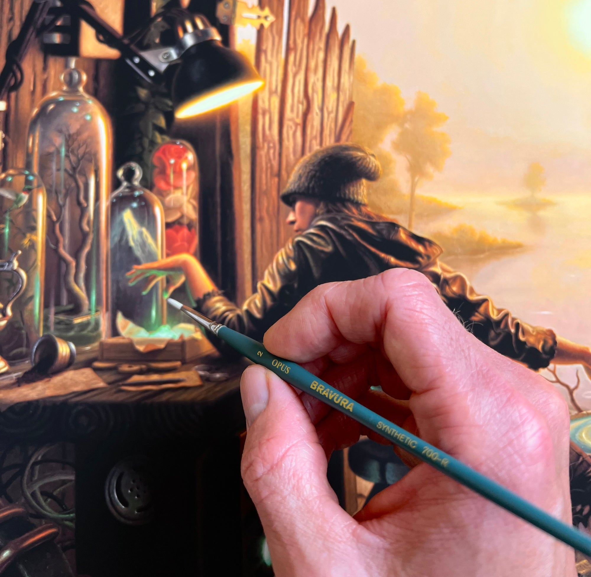 Hand holding a pencil in front of a painting of a person in a fantasy setting with a lamp and decorative objects.