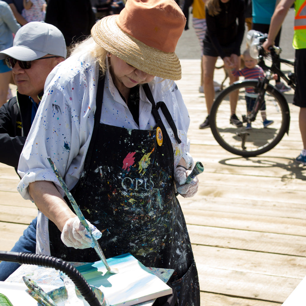 An artist painting at Opus Plein Air Challenge at Granville Island