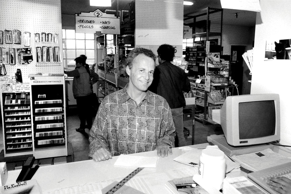Black and white photograph of Opus Founder David van Berckel at the Opus Art Supplies Granville Island location in 1987. 