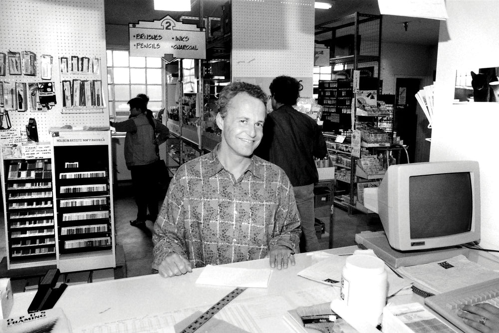Black and white photograph of Opus Founder David van Berckel at the Opus Art Supplies Granville Island location in 1987.