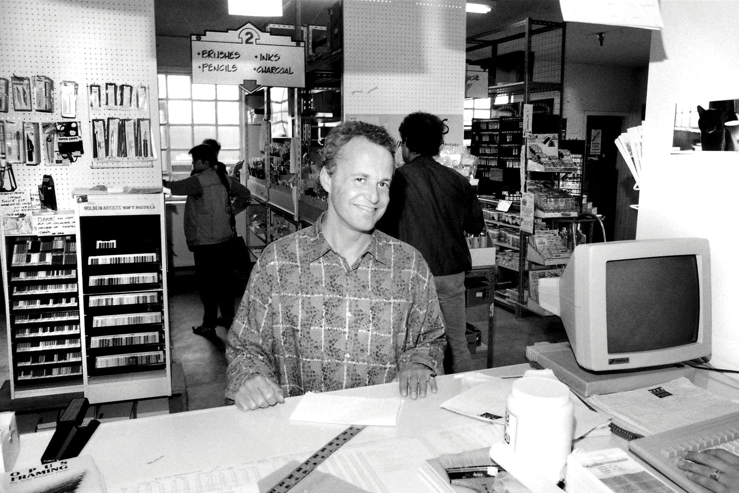 Black and white photograph of Opus Founder David van Berckel at the Opus Art Supplies Granville Island location in 1987.
