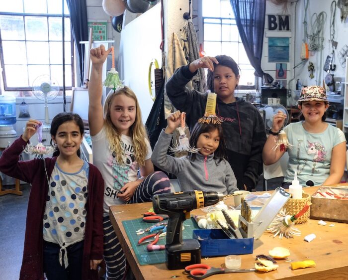 Young artists showing off their work in an Eastside Artist's studio space.