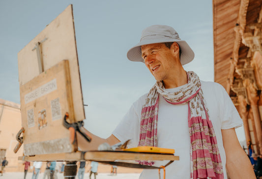 Artist Charlie Easton painting outdoors in India during a plein air session