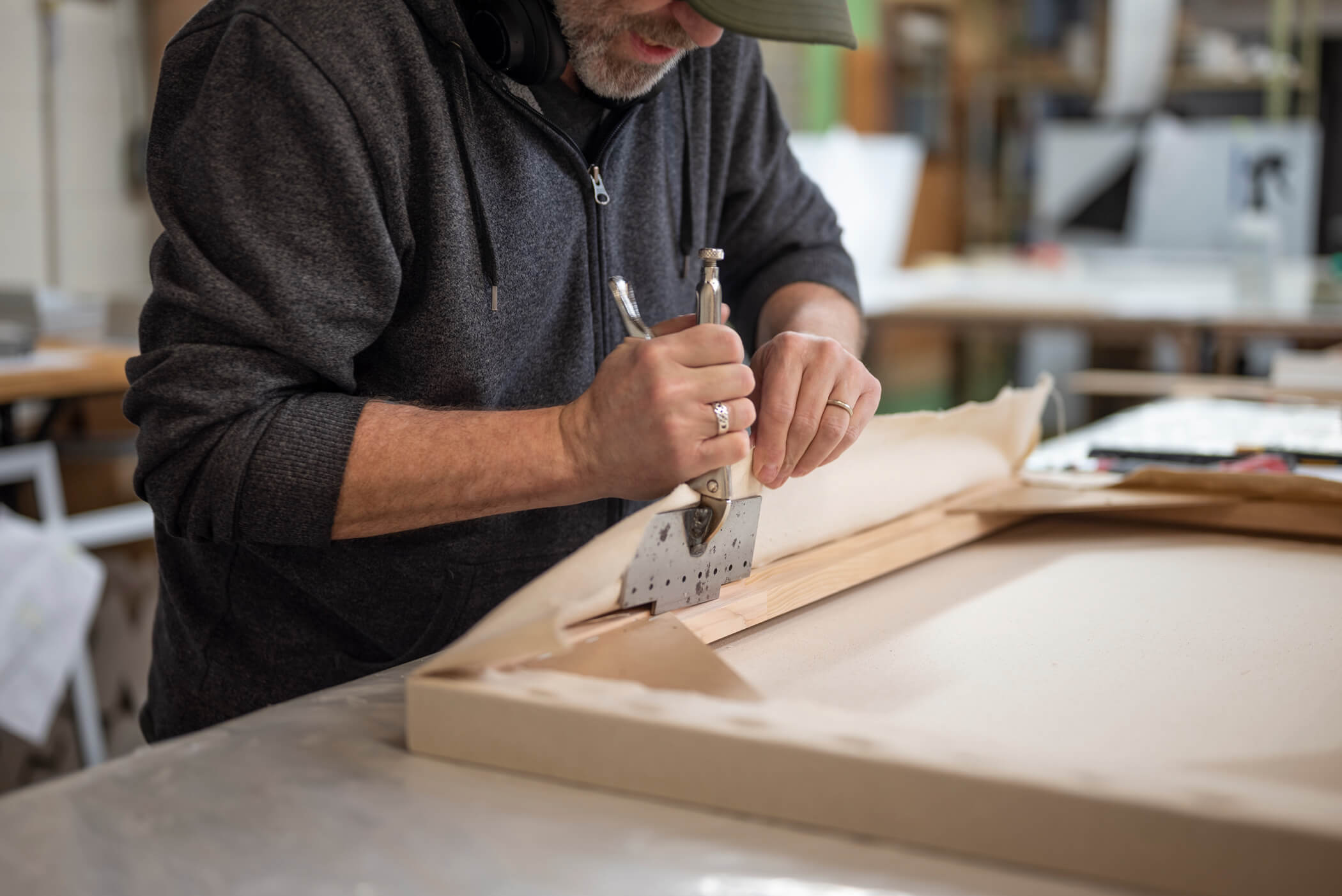 Opus staff using canvas pliers to stretch Opus Finest Canvas
