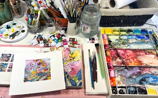Rose Cowles' studio workspace featuring artist materials, watercolour palettes, brushes and paintings in progress.