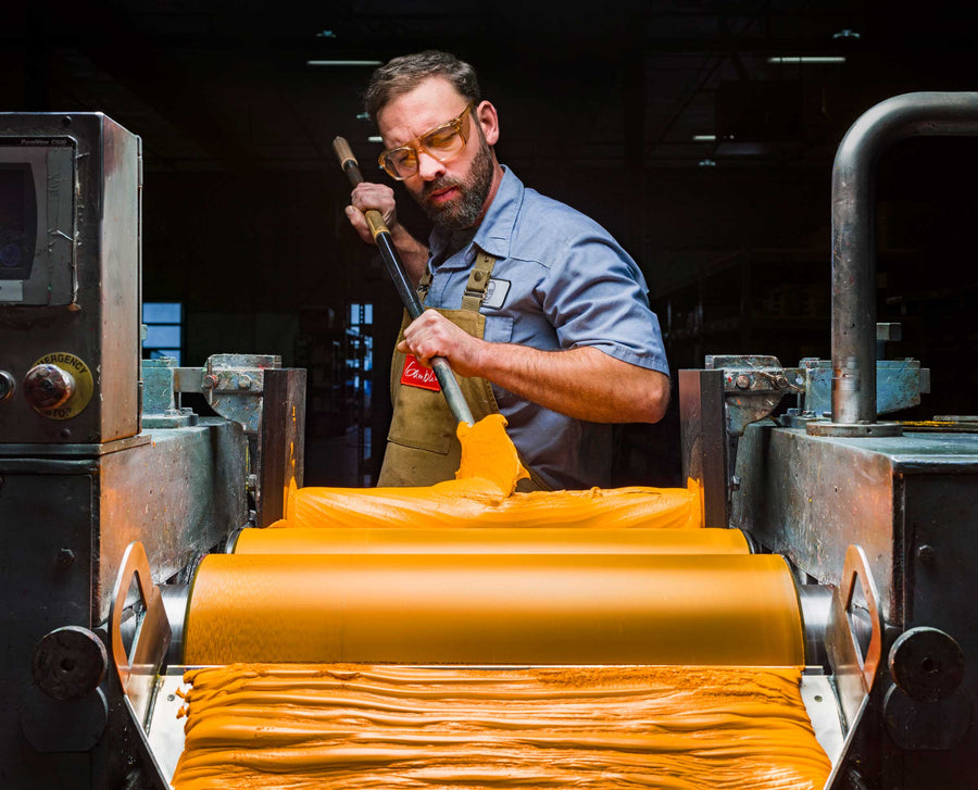 A colormaker manipulates paint on the mill at Gamblin Artist Colors' factory