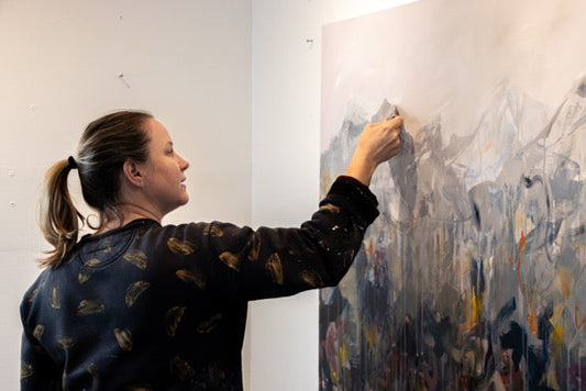 Artist Lisa Ochowycz painting on an abstract landscape in her East Vancouver studio