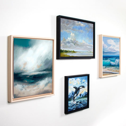 four paintings on the wall, all with west coast ocean scenes, framed with Opus Studio Frames in Black and Natural.