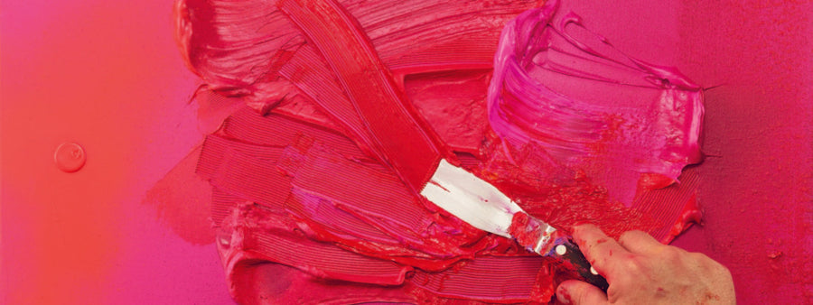 Spreading bright red acrylic paints with a painting knife