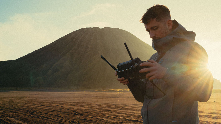 Emmett Sparling operating a drone at the base of a mountain