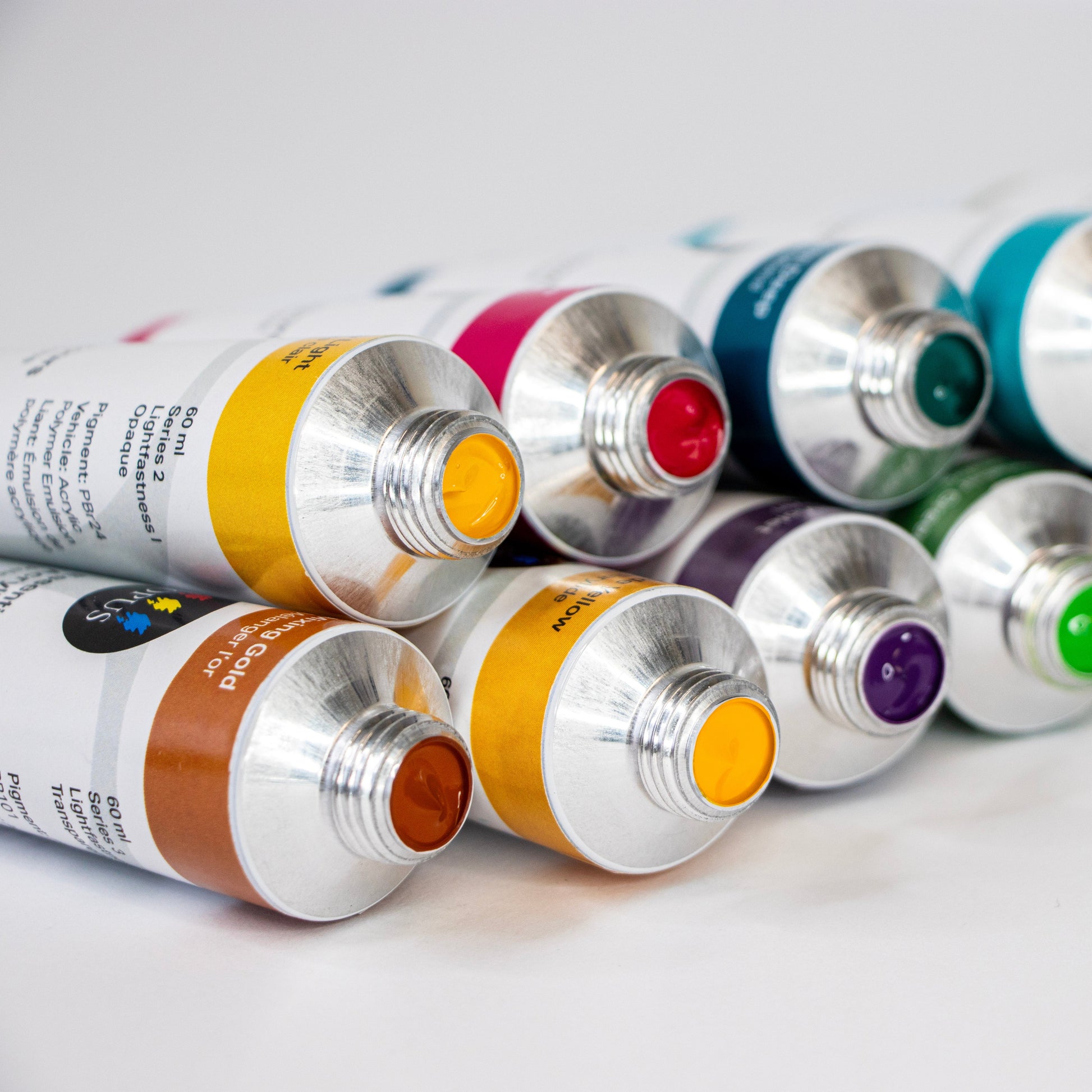 Set of paint tubes with metallic silver caps on a light gray background