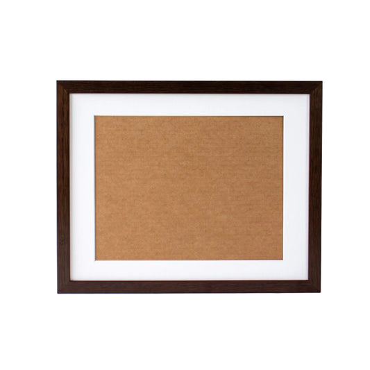Brown cork bulletin board in a dark wooden frame on a white background