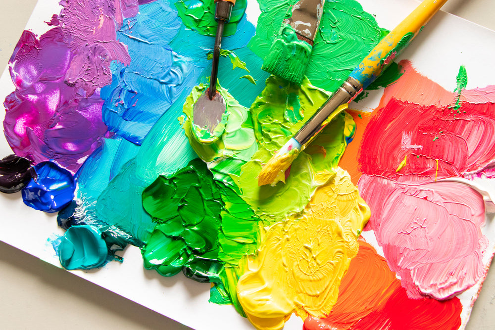 Rainbow of paint colours on a palette