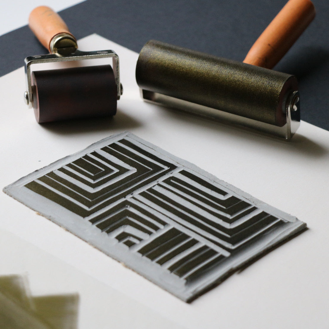 Two printing rollers and a stenciled design on paper