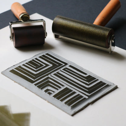 Two printing rollers and a stenciled design on paper